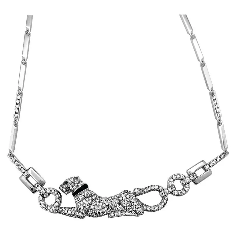 An 18 k white gold Cartier necklace, ?Panther? collection. The feline is entirely paved with brilliant-cut diamonds, his eye is enhanced with an emerald, the necklace he wears and his nose are enhanced with an onyx. Ref. N7048600 Panther?s dimensions : 57 x 19 x 5 mm. (2.244 x 0.75 x 0.197?) Total Length : 420 mm (16.54 inches) Diamond weight : 3.71 carats Weight: 52 grams Price: Upon request *Please note that the carat weight, number of stones and size of Cartier products made in the Coral jewelry factory may vary depending on the size of the piece ordered. Please contact us for more information.2